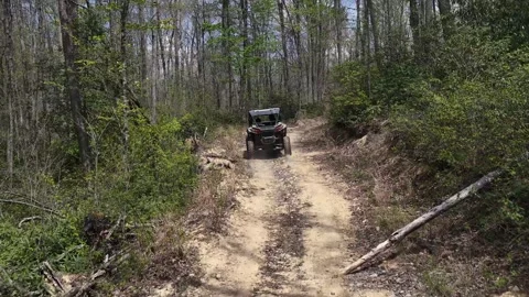 Drone following side by side on dusty path in the woods 스톡 동영상 344999344