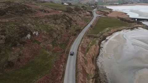 A drone follows a car driving down the road near Mizen Head Stock Footage 233195280