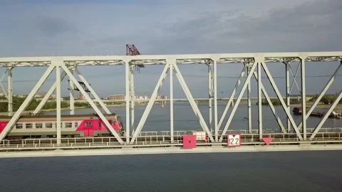 The drone follows an electric train that moves across a railway bridge Stock Footage 138854561