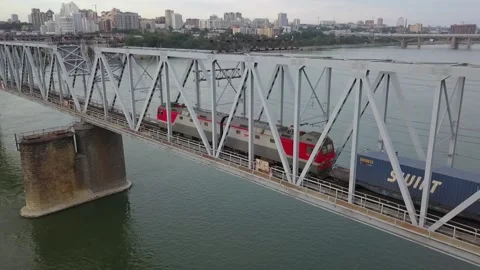 The drone follows a freight train that moves across a railway bridge. Stock Footage 138854825