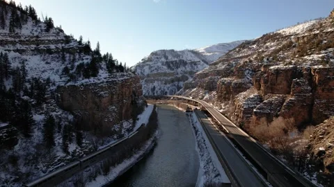 Drone follows Train driving through snowy Rocky Mountains Colorado next to river Vidéo 296548506