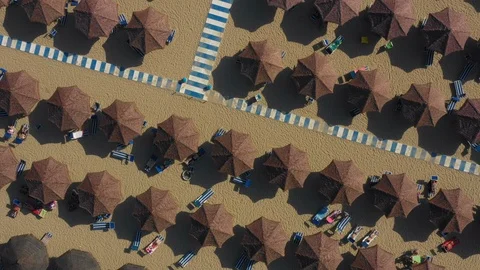 Drone Footage Of 180 Spin Hovering Over Brown Beach Umbrellas And Walkway Видео 111341126