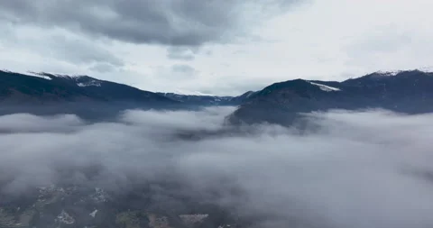 Drone footage above the clouds with mountains in the background. Morning shoot Stock Footage 174437962