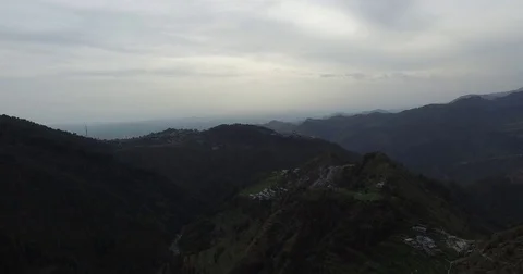 Drone footage backing away from dark green mountains Stock Footage 80982864