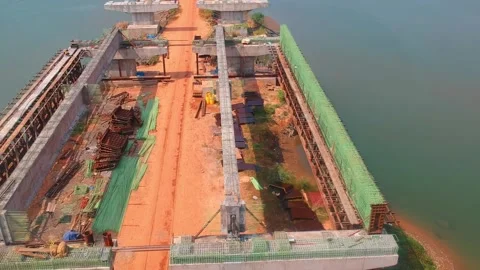Drone footage of the bridge under construction across the river At Kerala Stock Footage 160086598