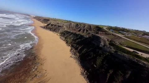 Drone footage captures dramatic cliffside beach with ocean surf Video stock 346077675