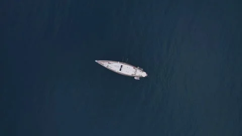 Drone footage captures a top-down view of a solitary yacht on the Mediterranean 動画素材 316213638