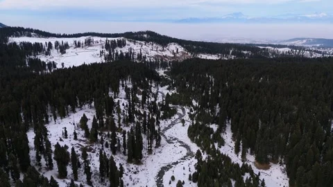 Drone footage capturing the contrast of flowing water against frozen Stock Footage 311793907
