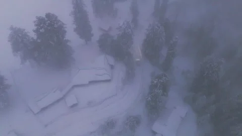 Drone footage capturing dramatic drive in evening snow squall. Stock Footage 311947488
