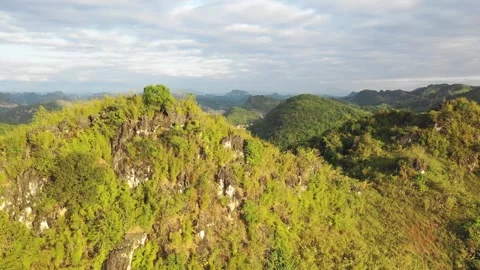 Drone footage capturing the lush green mountains and rocky hills surrounding the Stock Footage 346664649
