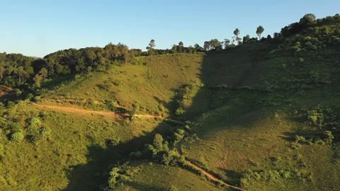 Drone footage capturing the lush green hills and forested slopes of the Mang But Stock Footage 346672412