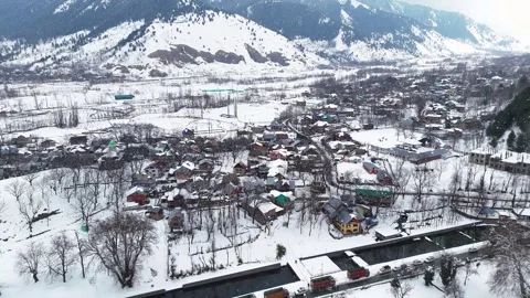 Drone footage capturing a peaceful winter morning in Verinag village under soft Stock Footage 311129336