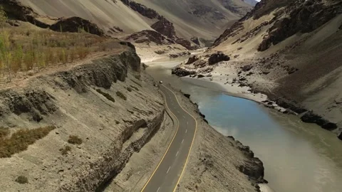 Drone footage capturing the perfect alignment of road and river carving their Stock Footage 310806746