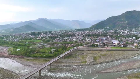 Drone footage capturing the serene flow of the river with Poonch city standing Stock Footage 311793575