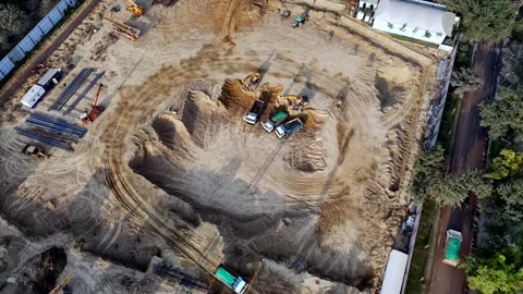 Drone footage capturing an under-construction plot where excavators and trucks Video stock 328219660