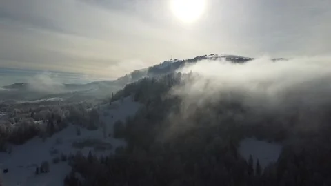 Drone Footage of Clouds Drifting Over Snow-Covered Mountains Stock Footage 324565694
