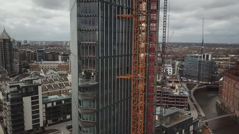 Drone footage of construction workers at height working on a glass skyscraper. Vídeo Stock 87863659