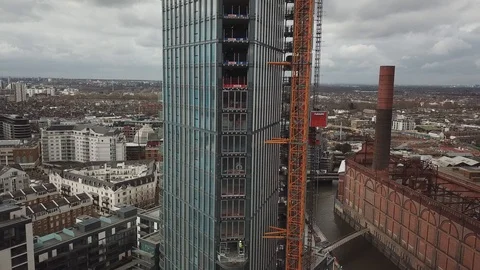 Drone footage of construction workers at height working on a glass skyscraper. Stock-Footage 87869505