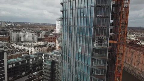Drone footage of construction workers at height working on a glass skyscraper. Stock-Footage 87869815