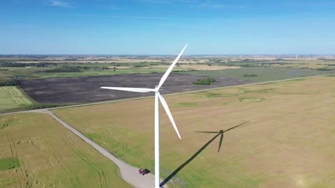 Drone footage descending vertically alongside a massive, modern wind turbine Stock Footage 316638218