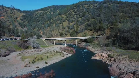 Drone Footage. Drone moves parallel to the bridge over a mountain river Video stock 303749454