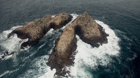 Drone footage featuring multiple shots of a rocky island on the coast Stock Footage 93781298