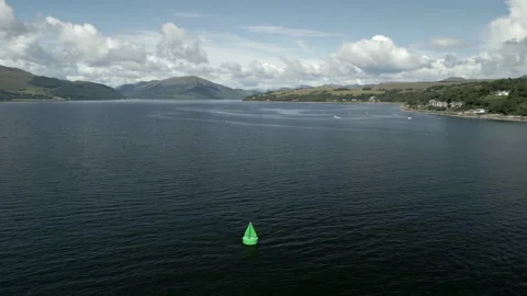 Drone footage - flyover of navigation buoy (green) in Scottish loch, 4K. Video stock 248796593