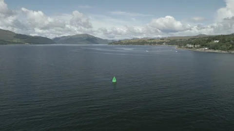Drone footage - flyover of navigation buoy (green) in Scottish loch, 4K RAW. Video stock 249083231