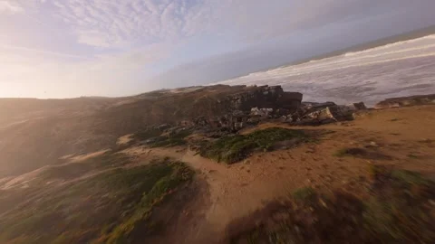 Drone footage glides over steep cliffs where ocean meets sky at golden hour Stock Footage 344678633