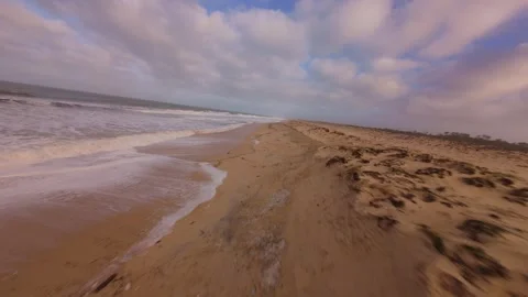 Drone footage gliding over wet sand with receding tide Stock Footage 345149306