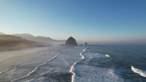 Drone Footage of Haystack Rock off Cannon Beach during a foggy sunrise Stock Footage 244349590