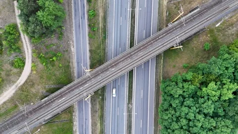 Drone footage of highway intersecting with railroad track and traffic durin.. Vidéo 281925113