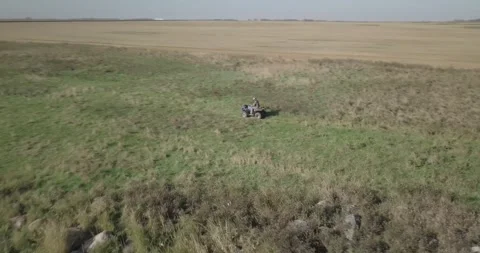 Drone footage of hunter driving four wheeler ATV through prairie Stock Footage 318103251