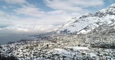Drone footage of ice-covered Dal Lake with surrounding snow-laden landscapes. Stock Footage 310656374
