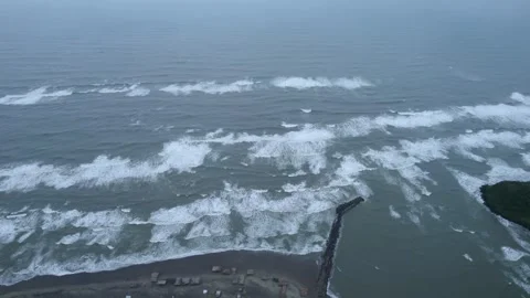 Drone footage in jib down with view of function of breakwater and waves Stock Footage 242427995