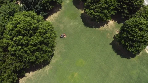 Drone footage looking down on a riding mower from above as it cuts grass on a Stock Footage 113987567