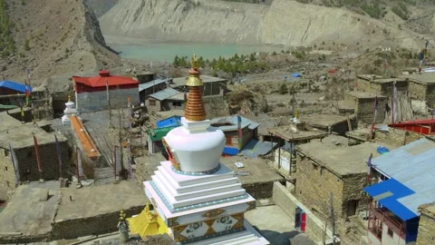 Drone footage of Manang’s traditional rooftops in front of the Gangpurna lake in 動画素材 311018596