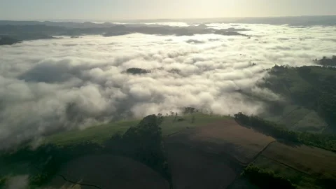 Drone footage of mountains among the clouds. Green fields and crops. Stock Footage 332260289