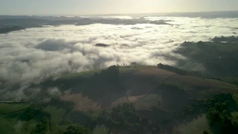 Drone footage of mountains among the clouds. Green fields and crops. Stock Footage 332260347