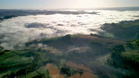 Drone footage of mountains among the clouds. Green fields and crops. Stock Footage 332260509