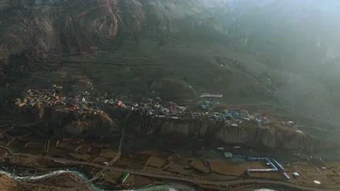 Drone footage of the perfect harmony between village, mountain, and morning Stock Footage 311019002