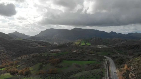Drone footage of a road passing through a forest with mountains and trees Stock Footage 128190023