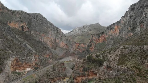 Drone footage of a road passing through a gorge with mountain range in Greece Stock Footage 128190645
