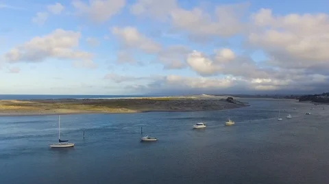 Drone footage of sand dunes with boats moored in estuary Stock Footage