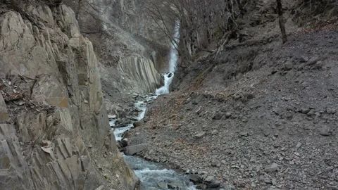 Drone Footage of Scenic Waterfall Between Rugged Mountains Stock Footage 303589730