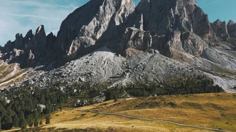 Drone footage of sharp Dolomite peaks rising above alpine meadows in Italy. Stock Footage 316804726