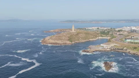 Drone footage showcasing the iconic Torre de Hercules lighthouse on a rocky Stock Footage 346709799