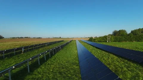 Drone footage showcasing rows of solar panels installed in lush green field Video stock 283424610