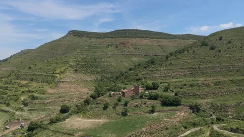 Drone footage showing a wide view of terraced green hills and a traditional Stock Footage 346710202