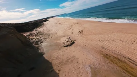 Drone footage shows steep cliffs, sandy shore, and foamy ocean waves Stock Footage 340905579
